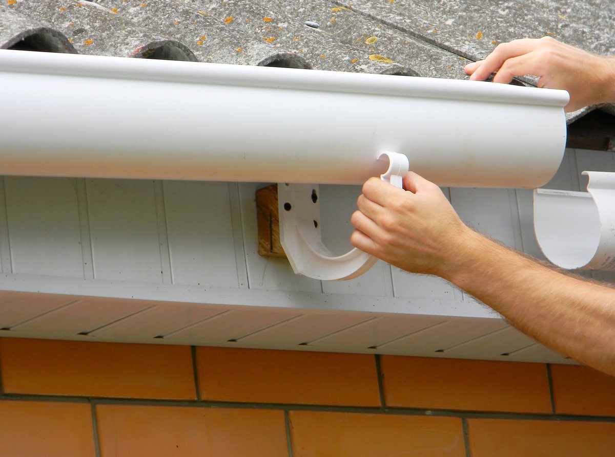 Contractor working on a roof gutter to repair seams and prevent water leaks