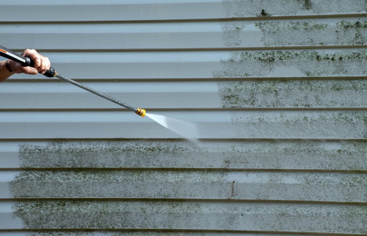 Cleaning mold from vinyl siding on an exterior house wall